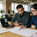 Two flowOne co-founders collaborating at a clean office table reviewing product workflow and architecture
